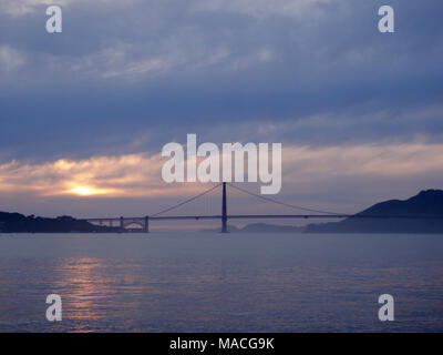 Tramonto sulla Baia di San Francisco e il Golden Gate Bridge con gli uccelli in aria e incredibili nuvole nel cielo in California. Marzo 16, 2010. Foto Stock