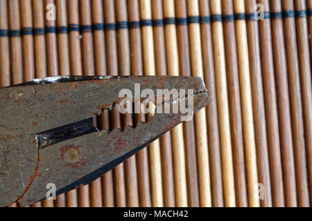 Testa della pinza noto anche come naso appuntito di pinze o pinze a becchi lunghi isolati su sfondo di legno. Foto Stock