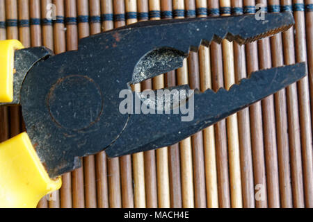 Testa della pinza noto anche come naso appuntito di pinze o pinze a becchi lunghi isolati su sfondo di legno. Foto Stock