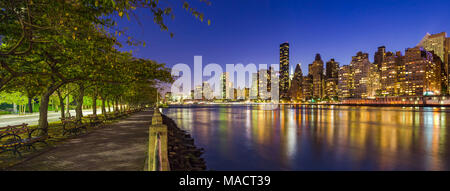 Vista panoramica di Midtown Manhattan grattacieli e l'East River al crepuscolo da Roosevelt Island promenade in estate. La città di New York Foto Stock