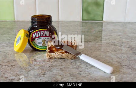 Aperto il vaso di marmite con diffusione sul pezzo di pane. Foto Stock