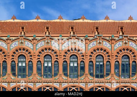 Ornate archi su una facciata modernista di Barcellona contro un cielo blu. Svuotare lo spazio di copia per l'editor di testo. Foto Stock