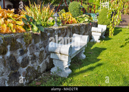 Antica pietra dorico panchina nel giardino di autunno Foto Stock