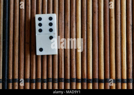 Pezzo di Domino sul bambù in legno marrone sfondo tabella. Set di Domino - due - 6 punti. Foto Stock