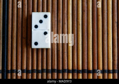 Pezzo di Domino sul bambù in legno marrone sfondo tabella. Set di Domino - due - 3 punti. Foto Stock