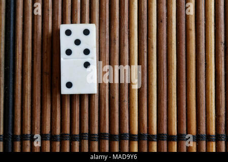 Pezzo di Domino sul bambù in legno marrone sfondo tabella. Set di Domino - due - 5 punti. Foto Stock