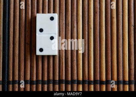 Pezzo di Domino sul bambù in legno marrone sfondo tabella. Set di Domino - due - 2 punti. Foto Stock