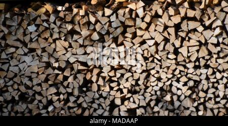 Pila di tronchi di legno di fronte a una casa, può essere utilizzata come sfondo o texture Foto Stock