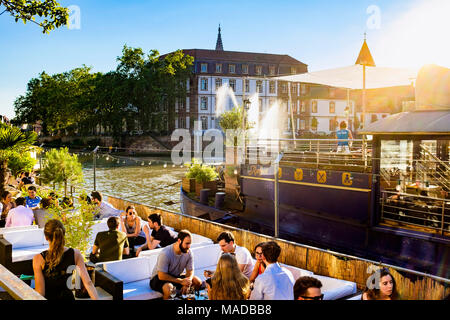 Il caffè con terrazza su chiatta, bar sulla barca, persone, fiume Ill, tramonto, estate, Strasburgo, Alsazia, Francia, Europa Foto Stock