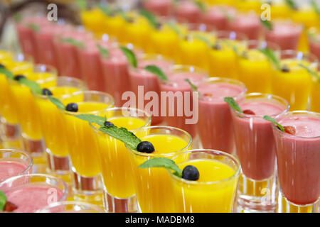 Catring colorati mousse di frutta dolce in vetro su specchio sfondi Foto Stock