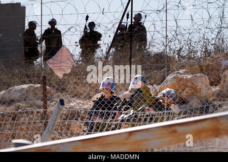 Bilin, Palestina, Dicembre 3, 2010: Israele Defense Force soldati gettando strappare i serbatoi di gas nel villaggio di Bilin durante manifestazioni settimanali contro Foto Stock