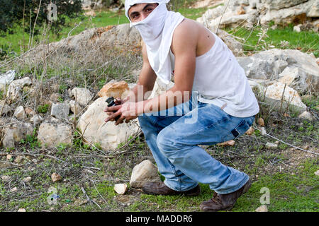 Bilin, Palestina, 1 Gennaio 2011: palestinese è in possesso di un gas lacrimogeni granata durante la dimostrazione contro la presenza israeliana in Cisgiordania. Foto Stock