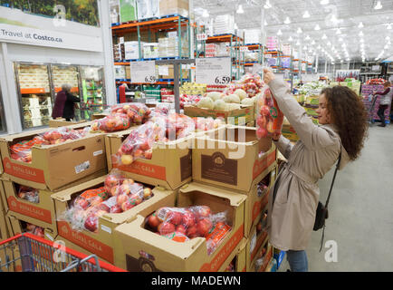 Licenza disponibile all'indirizzo MaximImages.com - donna che preleva un sacchetto di mele presso la sezione alimentare del magazzino di appartenenza Costco Wholesale. British Columbia, Foto Stock