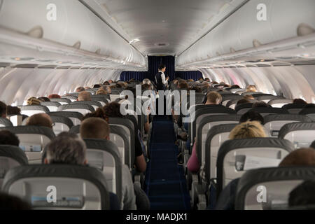 Cabina di in volo aereo passeggeri con volo specs mostra sul personale del  passeggero monitor poggiatesta Foto stock - Alamy