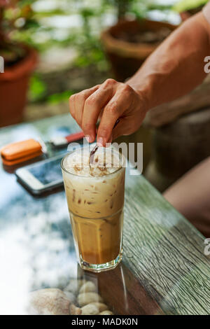 Uomo di paglia di contenimento sul caffè ghiacciato Foto Stock