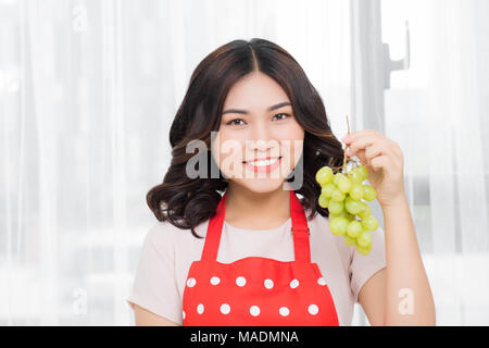 Mangiare sano, alimentari, frutta, dieta e concetto di persone - donna felice di mangiare uva a casa Foto Stock