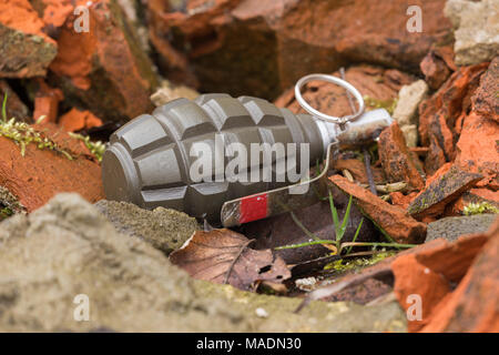 Hand Grenade giacente su un muro di mattoni Foto Stock