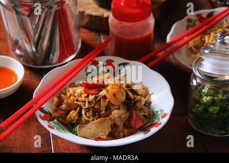 Fried Kway Teow, una strada popolare piatto di cibo di stir-fried piatto spaghetti di riso con pesce e frutti di mare, verdure e salsa di soia a Medan, nel nord di Sumatra. Foto Stock