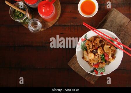 Fried Kway Teow, una strada popolare piatto di cibo di stir-fried piatto spaghetti di riso con pesce e frutti di mare, verdure e salsa di soia a Medan, nel nord di Sumatra. Foto Stock