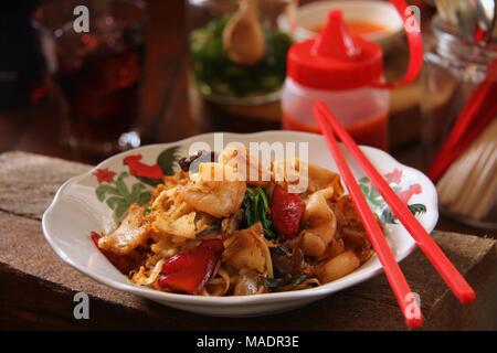 Fried Kway Teow, una strada popolare piatto di cibo di stir-fried piatto spaghetti di riso con pesce e frutti di mare, verdure e salsa di soia a Medan, nel nord di Sumatra. Foto Stock