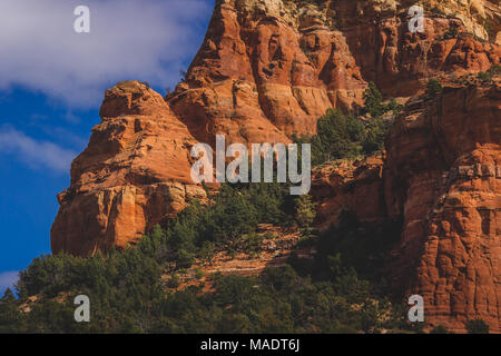 Vista dettagliata del Capitol Butte (aka Thunder Mountain) red rock formazione dal Dry Creek Vista in una giornata di sole con cielo blu e nuvole, Sedona, in Arizona Foto Stock