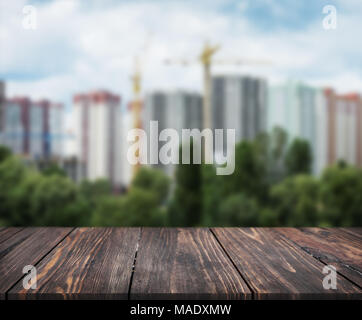 Immagine di un tavolo di legno nella parte anteriore di astratta sfocare lo sfondo del paesaggio della città. può essere utilizzato per visualizzare o montaggio dei vostri prodotti. Mock up per visualizzare Foto Stock