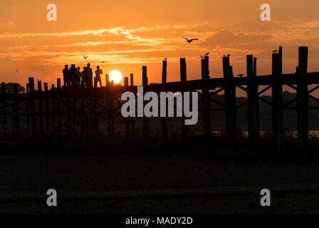 Le persone camminano sulla U Bein Bridge a sunrise, Amarapura, Mandalay Birmania (Myanmar) Foto Stock