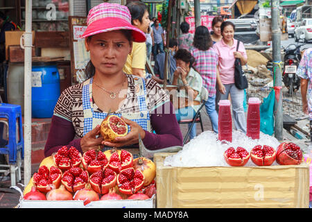 Donna street di stallo di vendita del fornitore del succo di melograno, Chinatown, Bangkok, Thailandia Foto Stock