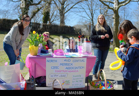 Merrick nord, New York, Stati Uniti d'America. 31 Mar, 2018. I volontari e gli ospiti, inclusi i bambini giocando con palloncini, sono da rosa tabella di entrata del Eggstravaganza annuale tenutosi presso Fraser Park e ospitato dal nord e dal centro di Merrick associazione civica (NCMCA) e Merrick's American Legion gruppo ausiliario 1282. Credito: Ann Parry/ZUMA filo/Alamy Live News Foto Stock