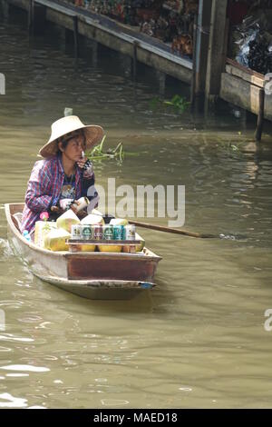 26 febbraio 2018, Thailandia, Damnoen Saduak: una donna pagaie nel mercato con la sua longtail boat che è riempito con la merce. Ella è la vela un canale nel Mercato Galleggiante di Damnoen Saduak. Questo mercato effettuate fuori dei canali è più di cento anni di età. Foto: Alexandra Schuler/dpa Foto Stock