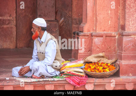 Uomo locali vendono fiori nel cortile della Jama Masjid in Fatehpur Sikri, Uttar Pradesh, India. La moschea è stata costruita nel 1648 dall'imperatore Shah Jahan Foto Stock