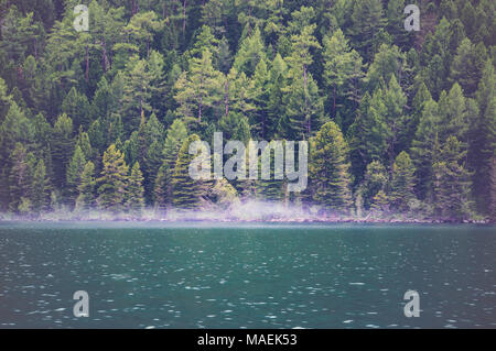 Vista sulle acque cristalline del lago con la nebbia e la riflessione sull'acqua. Foto Stock