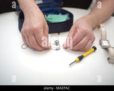 Una collana di riparare un ago come un piccolo strumento in mani femminili, macro shot Foto Stock