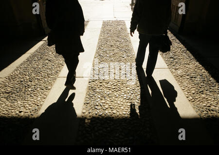 Due persone che camminano nella luce del sole lungo il vecchio sentiero di Torino, Italia. Foto Stock