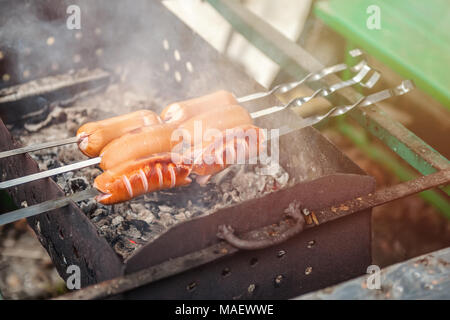 Delizioso, succosa salsicce alla griglia su spiedini su un fuoco aperto. Foto Stock