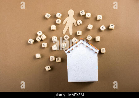 Lettera di legno cubi e figurine di uomo e modello di casa Foto Stock