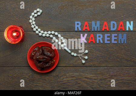 Table top visualizza immagine aerea di decorazione Ramadan Kareem holiday sfondo.piatto data di laici nella piastra di rosso con il bianco rosario & illuminazione.Il testo invitatio Foto Stock