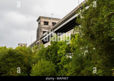 Guardando in alto attraverso gli alberi del Britannia Bridge, oltre il menai stretto tra Gwynedd e Anglesey. Il Galles del Nord, Regno Unito Foto Stock