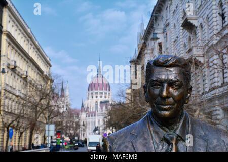Budapest, Ungheria - 28 Marzo 2018: Statua dell'ex U.S. Il Presidente Ronald Reagan sullo sfondo del parlamento ungherese edificio. Statua di sc Foto Stock