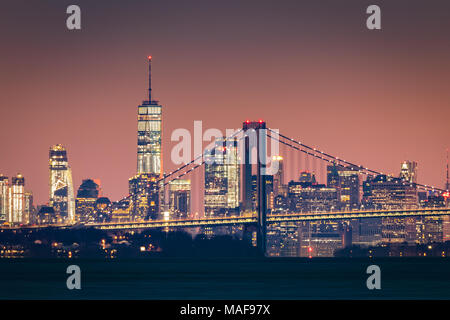 Skyline di Manhattan all'alba sorge dietro Verrazano Bridge Foto Stock