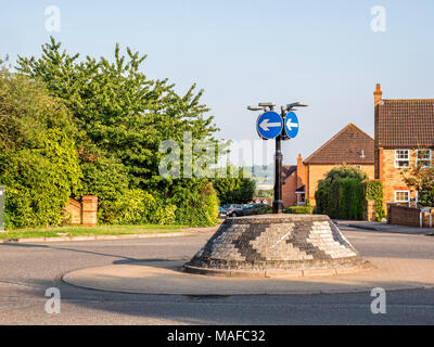 Visualizzazione giorno del tipico mattone inglese rotatoria con segnaletica direzionale. Foto Stock