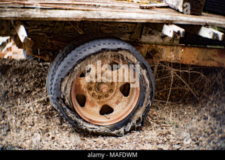 Un arrugginito 10 aletta ruota con una soffiata fuori a tele incrociate di pneumatico a heavy duty 1935 Chevy del carrello dello scanner a superficie piana, su di una collina in una vecchia cava di pietra, vicino a Clark Fork, Idaho Foto Stock