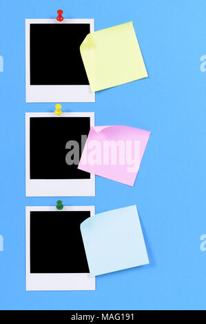 Blank Foto stampe con sticky notes appuntata a carta blu. Foto Stock