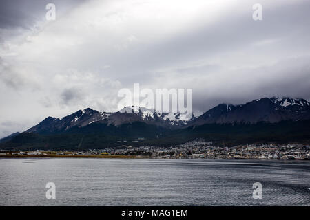 Bellissima vista drammatico del Canale di Beagle, con Snow capped mountain e la città visibile in distanza. Ushuaia, Patagonia, Argentina Foto Stock