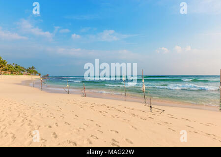 Bellissimo paesaggio marino, massi, palme e il luogo dei pescatori tradizionali su palafitte, Sri Lanka. Foto Stock