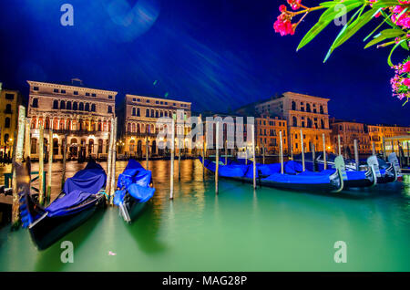 Italia venezia canal grande gondola pier fila ancorato per tutta la notte al tramonto sfocato illuminato a poli da acqua di mare lungo antichi palazzi Foto Stock