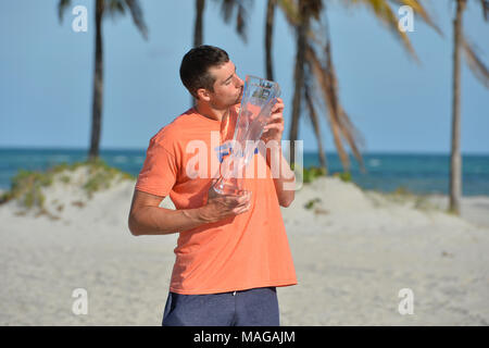 Miami, FL, Stati Uniti d'America. 1 apr, 2018. KEY BISCAYNE, FL - aprile 01: John Isner (USA) le teste per la stato di Crandon Park Beach per le immagini con il Campionato trofeo dopo la sconfitta di Alexander Zverev (GER) 67(4) 64 64 al 2018 Miami aperto presso il Centro Tennis di Crandon Park il 1 aprile 2018. Credito: Andrea, Patrono/filo di Zuma Credito: Andrea, Patrono/ZUMA filo/Alamy Live News Foto Stock