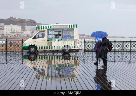 Hastings, East Sussex, Regno Unito. 2 apr, 2018. Bank Holiday UK Meteo: docce, drizzly pioggia nella località balneare di Hastings in questa Pasqua lunedì pomeriggio con un sacco di gente fuori e circa la schermatura stessi con ombrelloni. © Paul Lawrenson 2018, Photo credit: Paolo Lawrenson / Alamy Live News Foto Stock