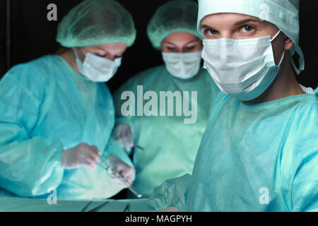 Primo piano dei chirurghi di eseguire l'operazione. Focus sul maschio medico. Medicina, chirurgia di emergenza e i concetti di guida Foto Stock