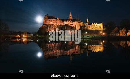 Il Castello Hohenzollern di Sigmaringen è situato direttamente sul Danubio, la luna piena accanto al castello si illumina le frazioni. Foto Stock